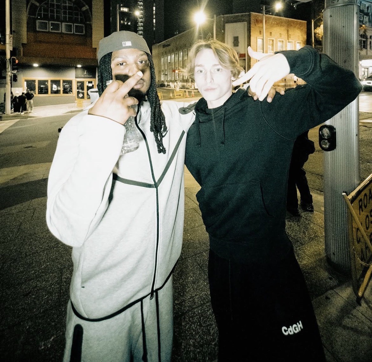 Two producers posing for a photo on a city street at night