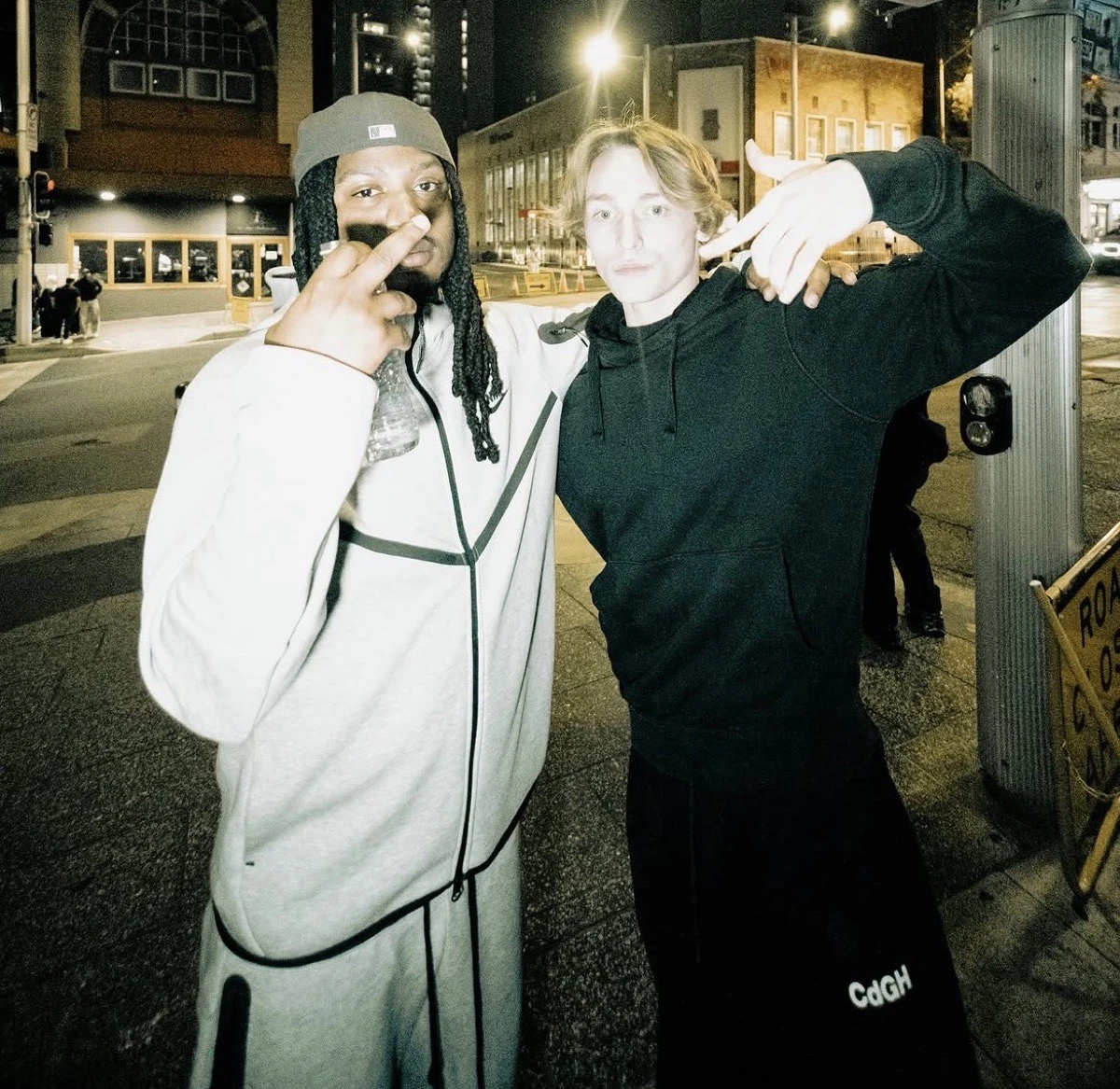Two producers posing for a photo on a city street at night