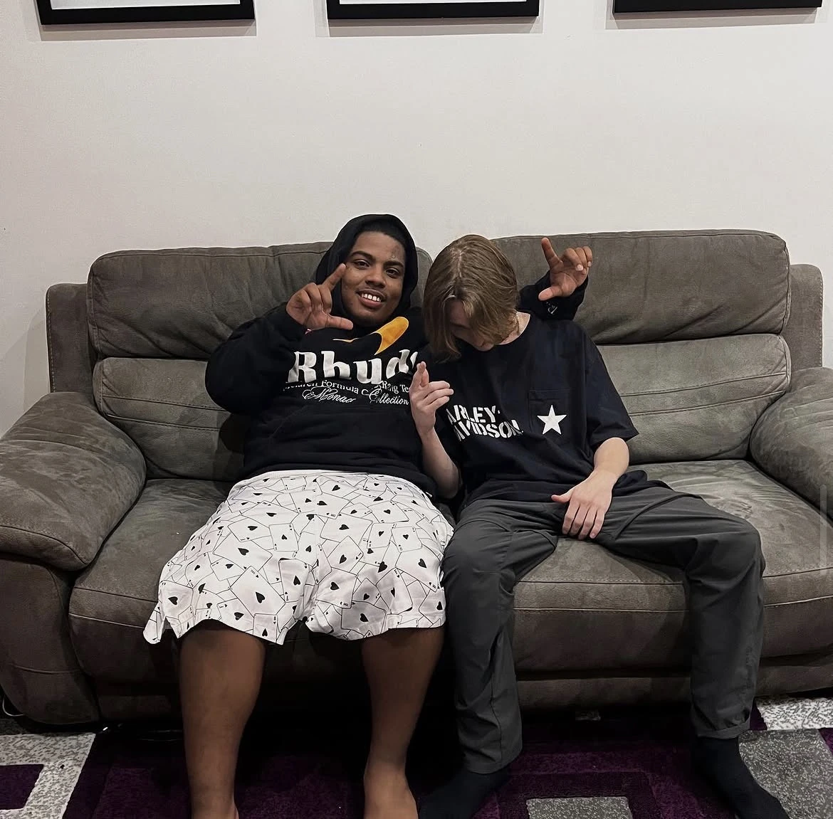 Two producers posing together on a couch
